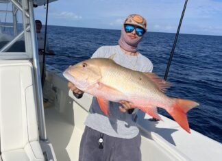 a man holding a fish on a boat