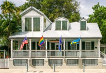 a white house with flags on the front of it