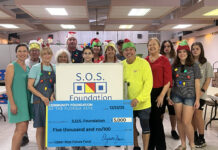 a group of people posing for a picture in front of a donation check