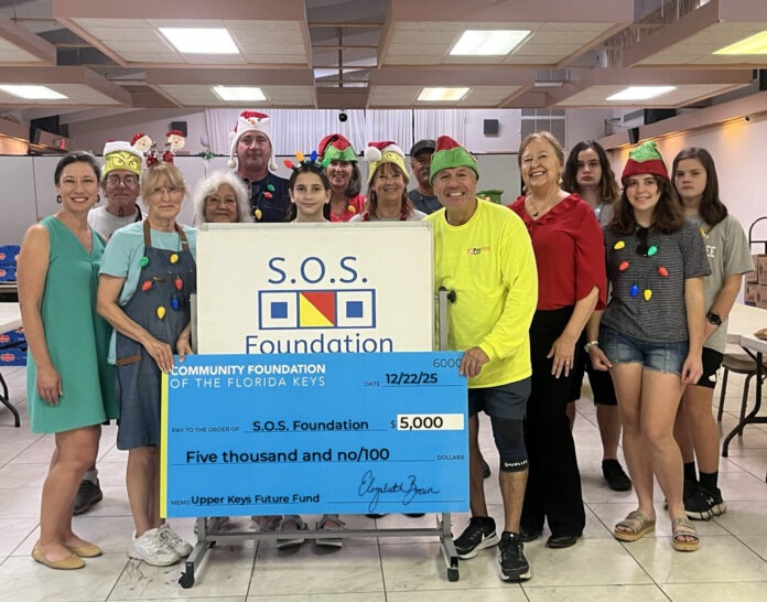 a group of people posing for a picture in front of a donation check