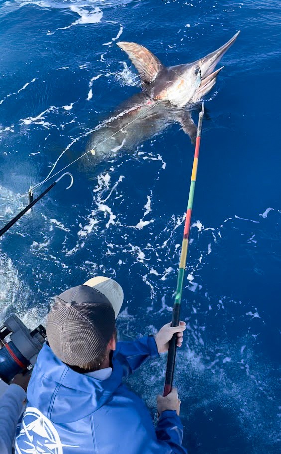 a man holding a fishing rod and a fish