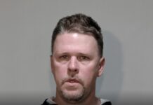 a mug shot of a man in a black hoodie