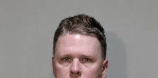 a mug shot of a man in a black hoodie