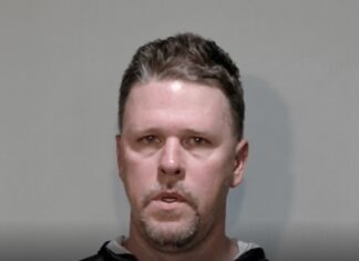 a mug shot of a man in a black hoodie