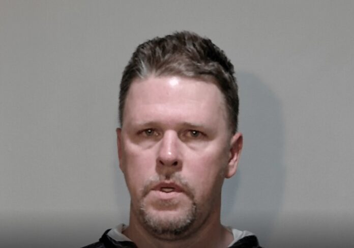 a mug shot of a man in a black hoodie