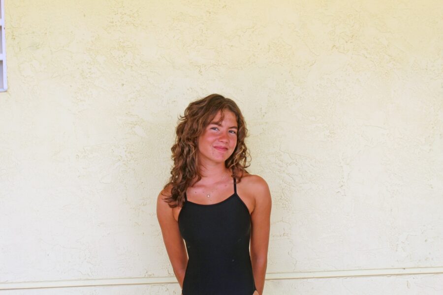 a woman standing in front of a white wall