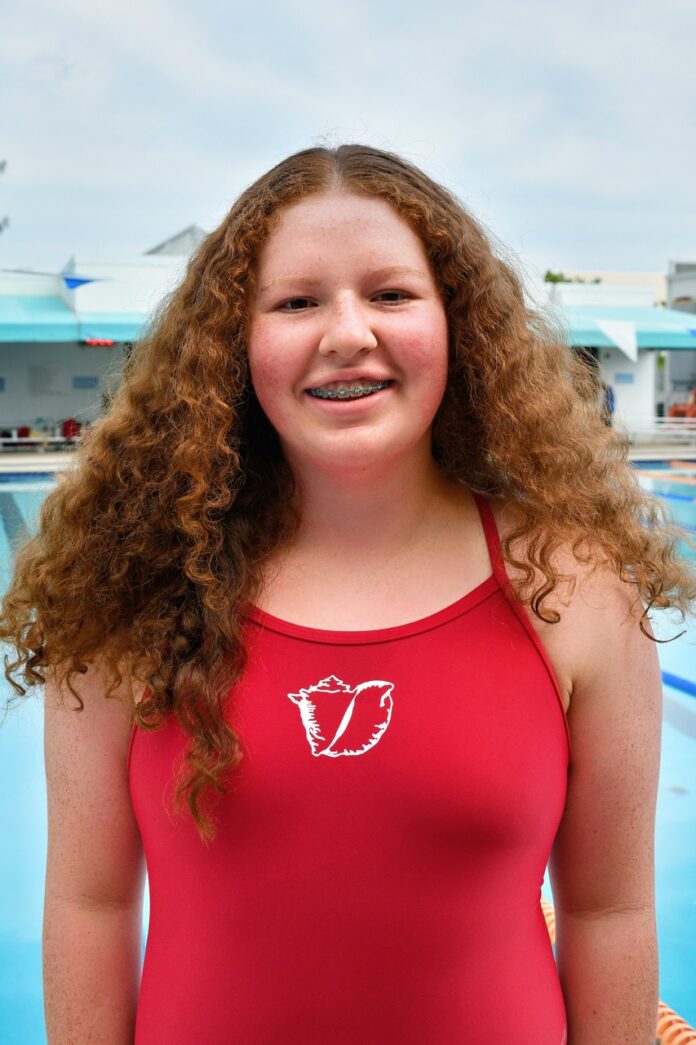 a woman standing in front of a swimming pool