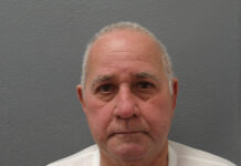 a man in a white shirt is looking at the camera