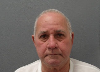 a man in a white shirt is looking at the camera