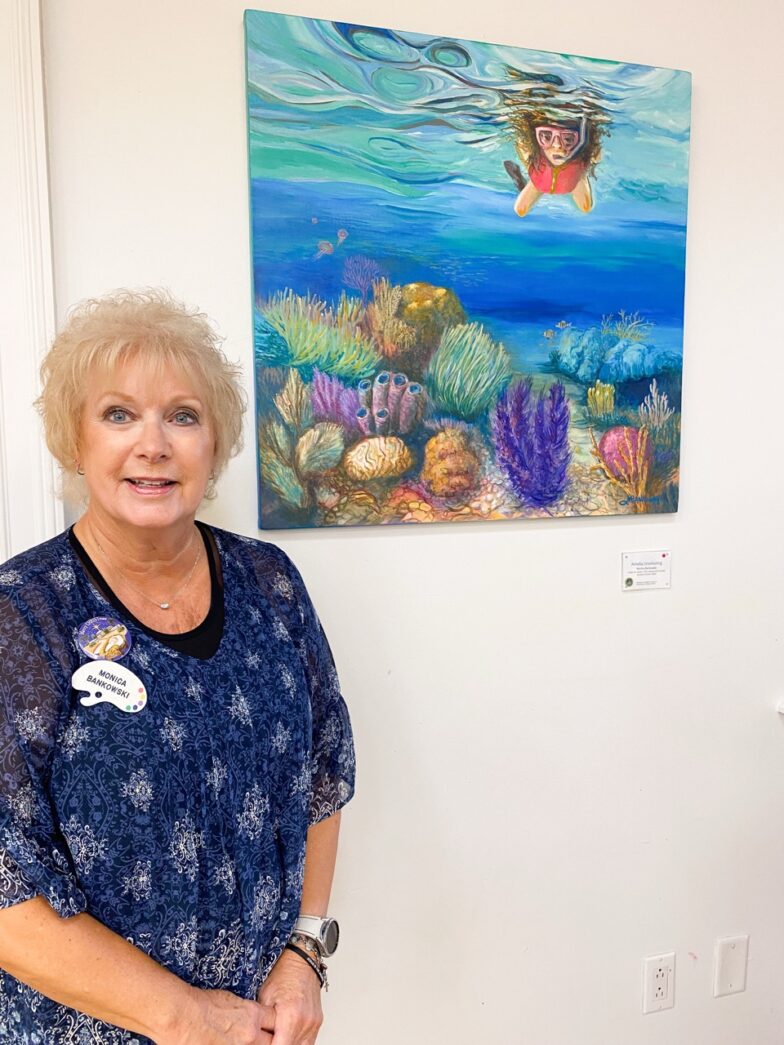 a woman standing in front of a painting