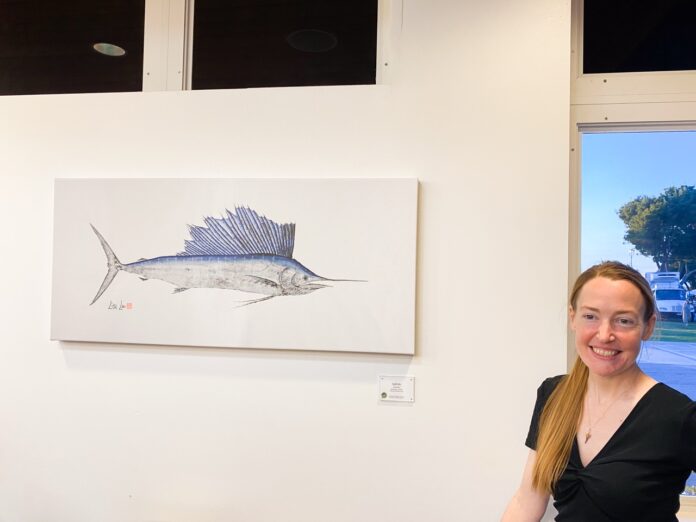 a woman sitting at a table in front of a painting