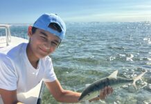 a man holding a fish on a boat