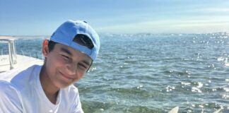 a man holding a fish on a boat