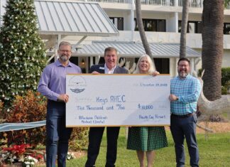 HAWKS CAY SHOWERS LOCAL NONPROFITS WITH $30K IN DONATIONS a group of people holding a large check in front of a building
