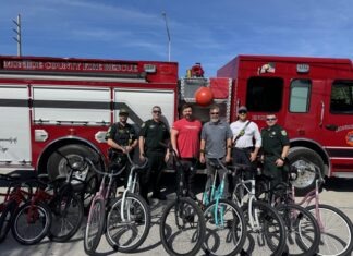 200 KEYS KIDS GET NEW BIKES FOR CHRISTMAS a group of men standing in front of a fire truck