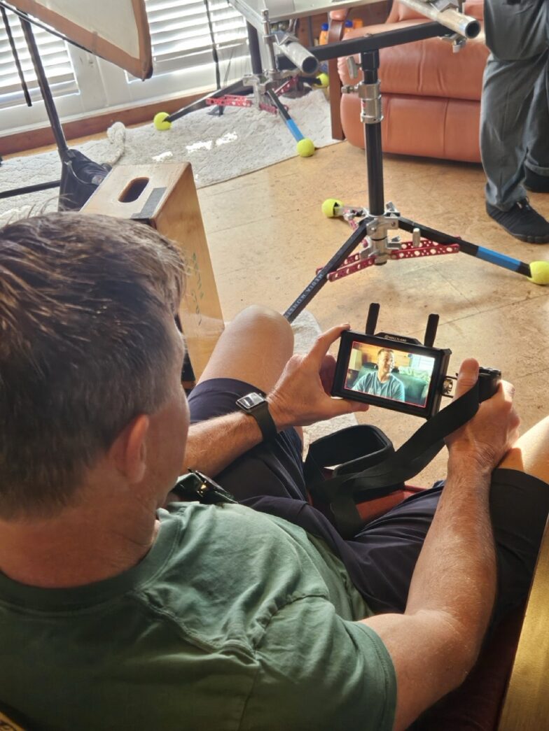 a man sitting in a chair holding a smart phone