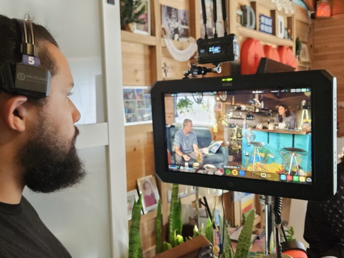 a man with a beard is looking at a video camera