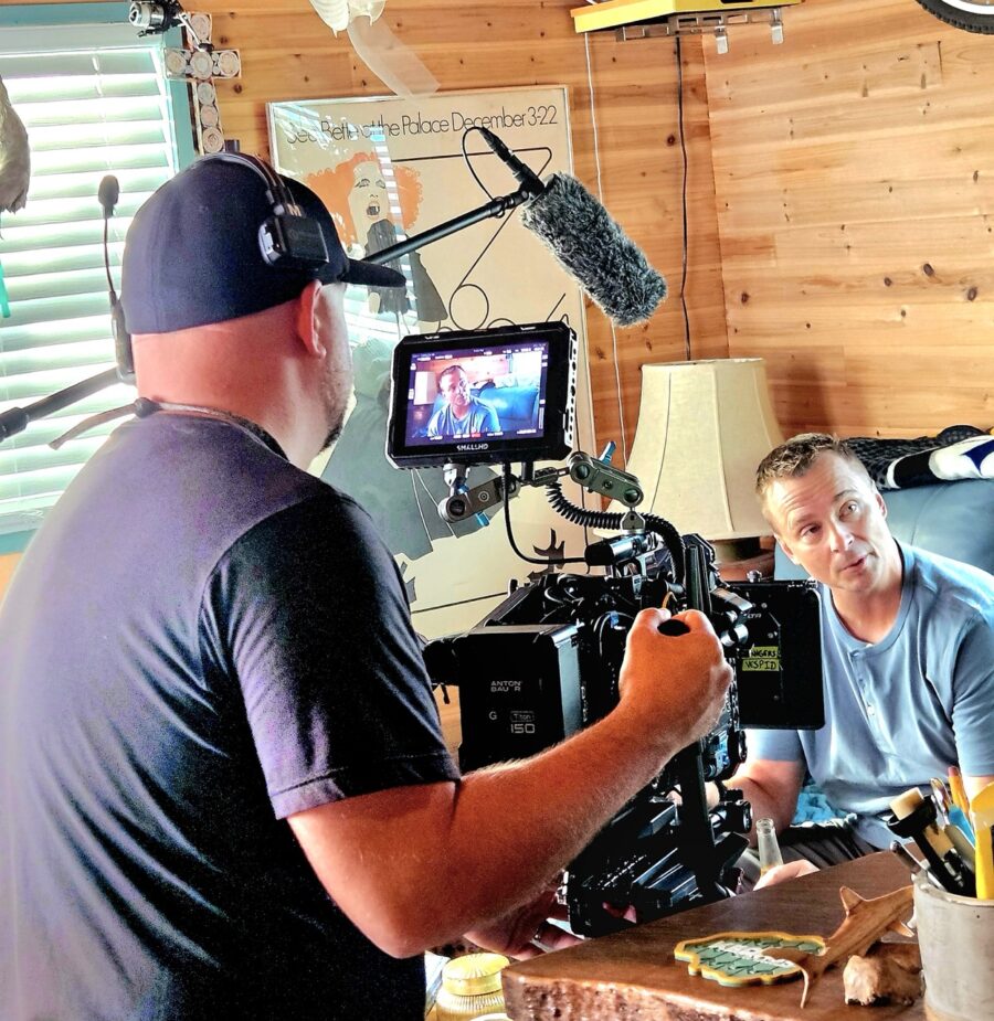 a man is filming another man in a room