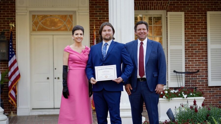 two men and a woman standing in front of a building