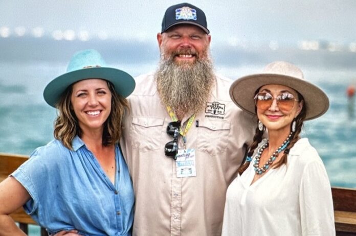 a man with a long beard standing next to two women