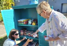 two women are looking at a cooler outside