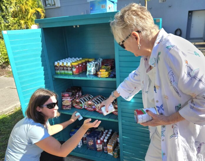 loading little pantry two women are looking at a cooler outside