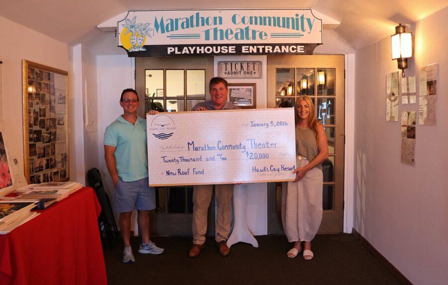 a group of people holding a large check in front of a building
