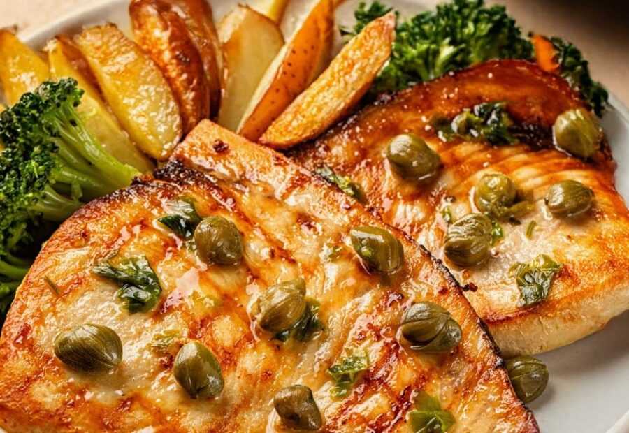 a white plate topped with fish, potatoes and broccoli